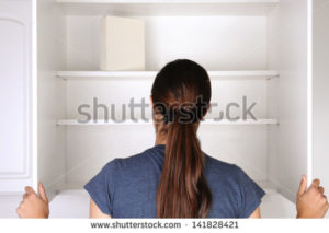 stock-photo-closeup-of-a-woman-looking-in-an-empty-pantry-seen-from-behind-there-is-only-one-box-of-food-141828421